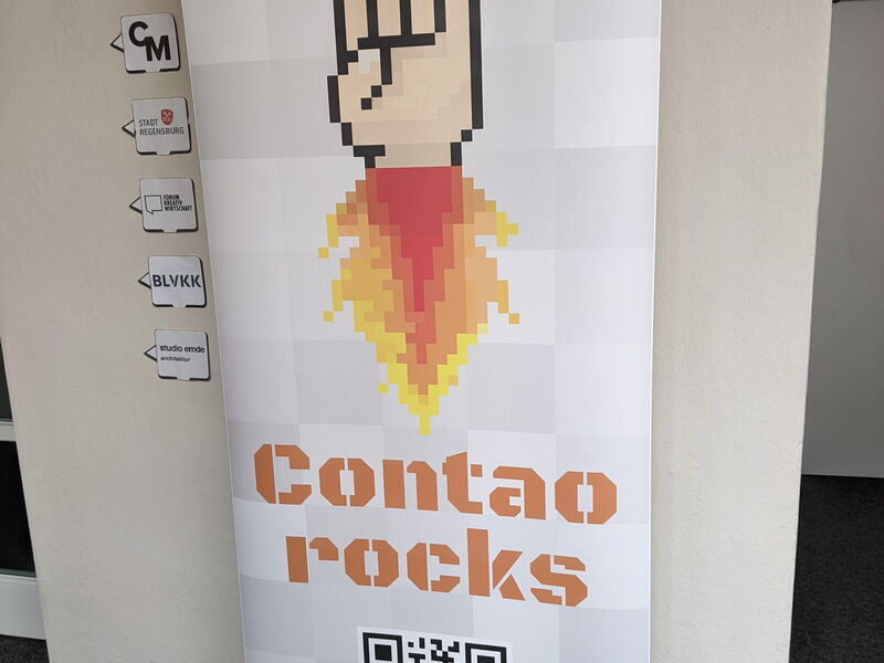 Roll-up „Contao rocks“ mit Pixel-Hand und Flamme im Flur