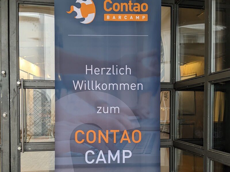 Roll-up „Herzlich willkommen zum Contao Camp“ in der Eingangstür des Degginger